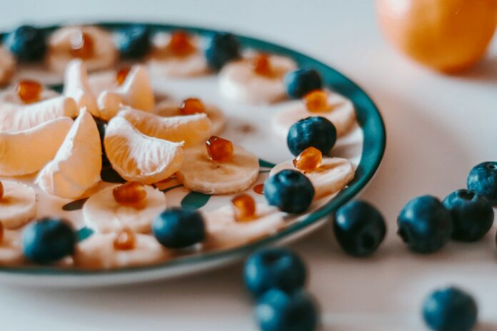 Photo by Adina Anghel sliced of orange fruit on white and blue ceramic plate