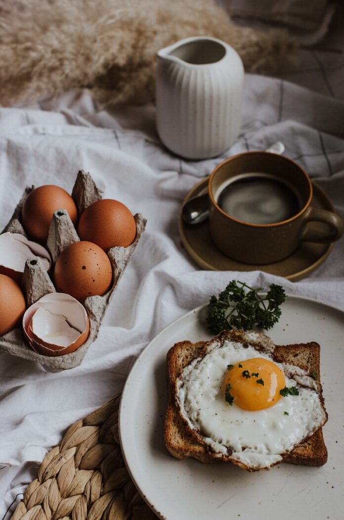 Photo by Priscilla Du Preez 🇨🇦 three eggs on white ceramic plate beside brown ceramic mug