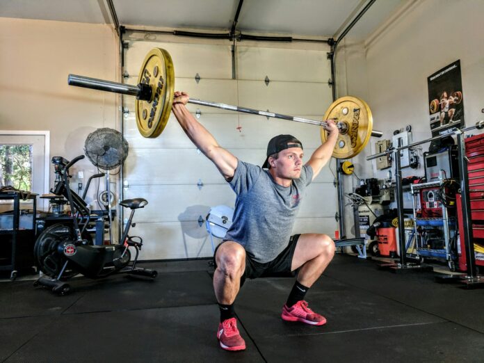 Photo by Sam Sabourin man lifting yellow barbell