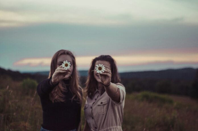 Photo by Sam McNamara two women holding flowers