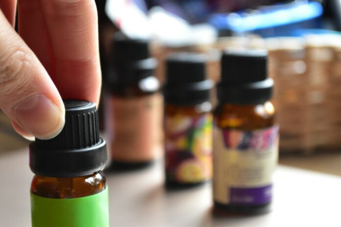 Photo by Sara Bach a hand touching a bottle of essential oils