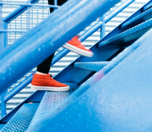 ‘하루 만보 걷기’에서 ‘정기적 움직임’으로… 최신 건강 습관 트렌드 변화 person stepping on blue stairs
