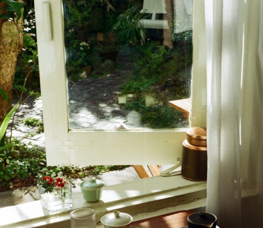 나를 돌보는 작은 실천, 일상 속 웰니스 문화 확산 Tea set arranged on a wooden tray by the window.