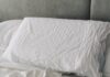 바쁜 일상 속 ‘슬기로운 숙면 습관’…한국인의 최신 수면 트렌드와 실생활 꿀팁 A rumpled white duvet and pillows on a bed.