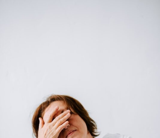 “만성피로, ‘작은 변화’가 만드는 큰 회복—최신 트렌드와 생활 루틴 팁” a woman sitting on a couch holding her hands to her face