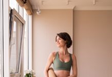 일상 속 필라테스, 내 몸을 위한 작은 변화의 시작 a woman in a green sports bra top and leggings holding a yoga mat