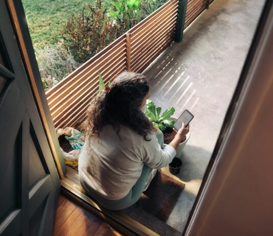 만성피로, 일상 속 작은 변화로 극복한다… 한국인 건강 루틴 새롭게 주목 Woman sitting on balcony with smartphone
