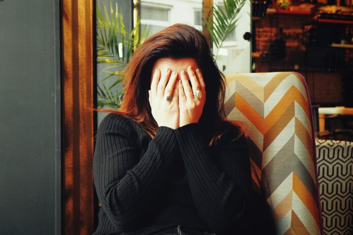 Photo by Ivan Aleksic woman in black long sleeve shirt covering her face