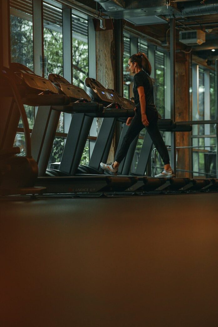 Photo by Mike Cox a woman running on a treadmill in a gym