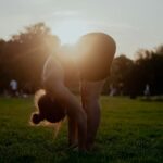 직장인 필수 건강 관리, 거북목·일자목 교정 위한 스트레칭 및 생활 습관 안내 woman in white bikini bottom kneeling on green grass field during sunset